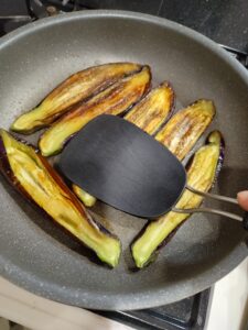 茄子をヘラで押し付けて焼く